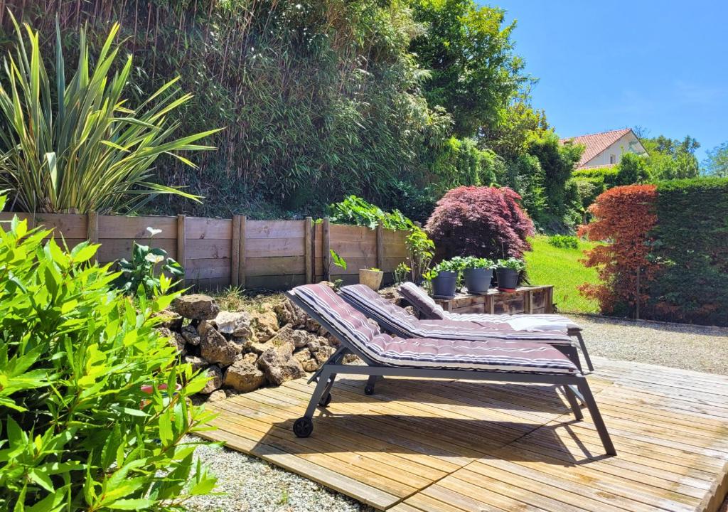 un banc installé sur une terrasse en bois dans un jardin dans l'établissement GALLEBEN - Coquette et confortable maison, à Capbreton