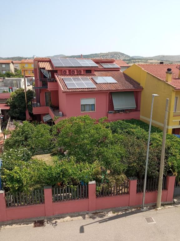a pink house with solar panels on top of it at Corona Bed & Breakfast in Sardara