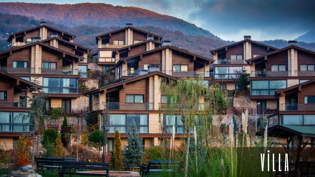 a large building with a mountain in the background at V Orman Resort in Mudurnu