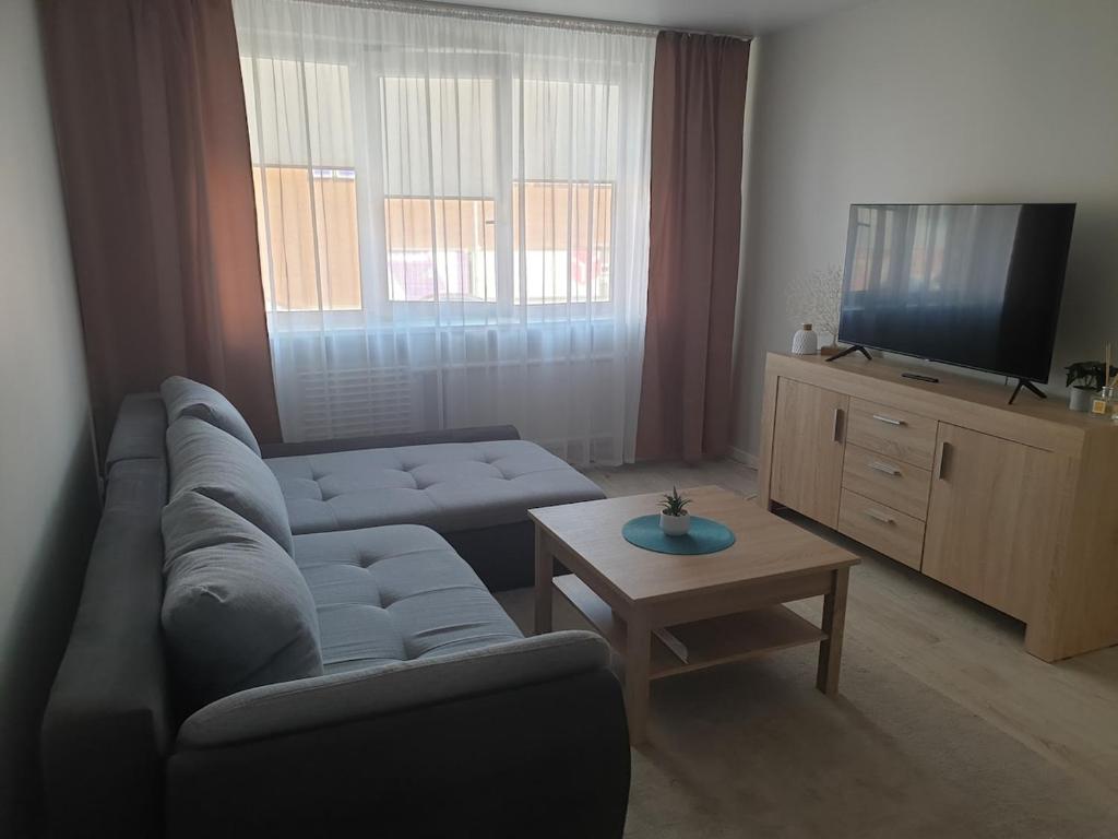 un soggiorno con un divano e una TV di Studio IT on Tumo a Plungė