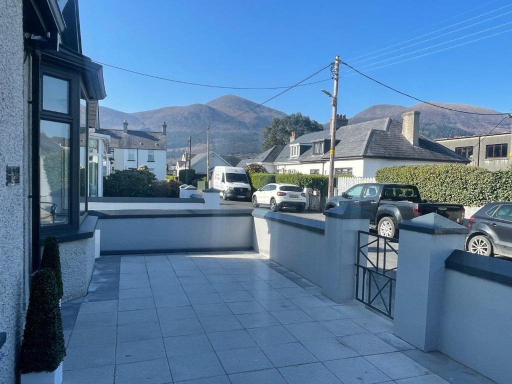 a house with a fence and cars parked in a street at Central cottage Newcastle in Newcastle