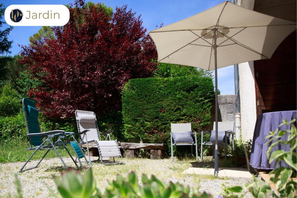 un groupe de chaises et un parasol dans une cour dans l'établissement Parenthèse de calme et de nature au bord du Verdon, à Gréoux-les-Bains