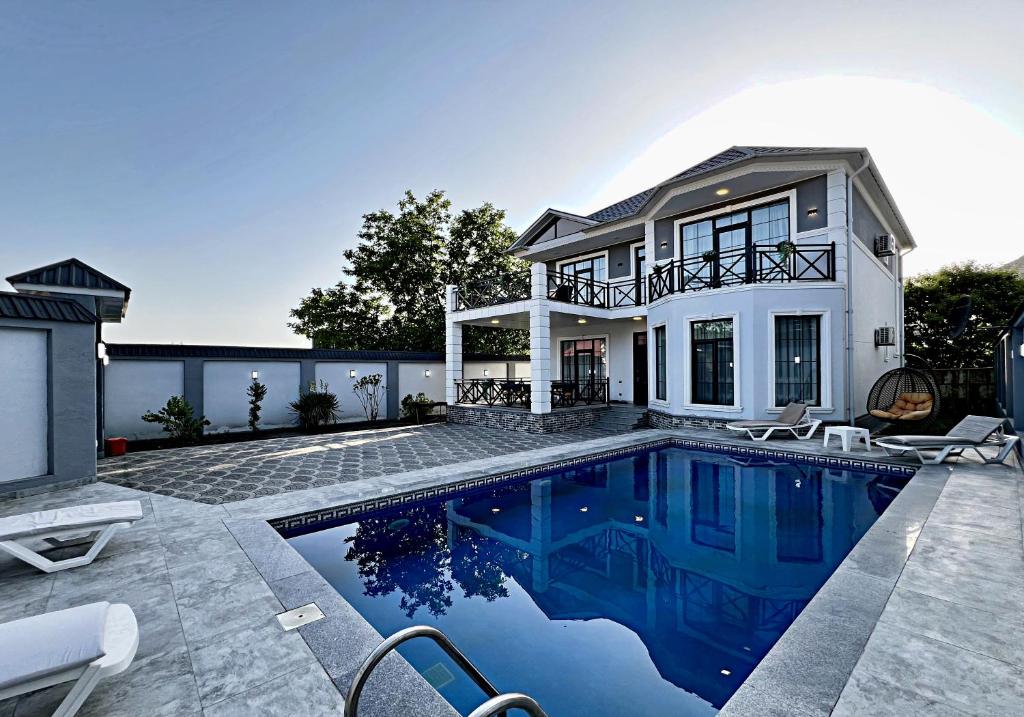 a house with a swimming pool in front of a house at Gabala tvins Villa in Gabala