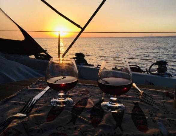 due bicchieri di vino seduti su un tavolo su una barca di Magnificent sailboat with free parking for cars a Valencia