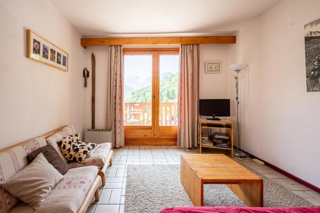 ein Wohnzimmer mit Sofa und Fernseher in der Unterkunft Les Arolles n°G54 in Valloire