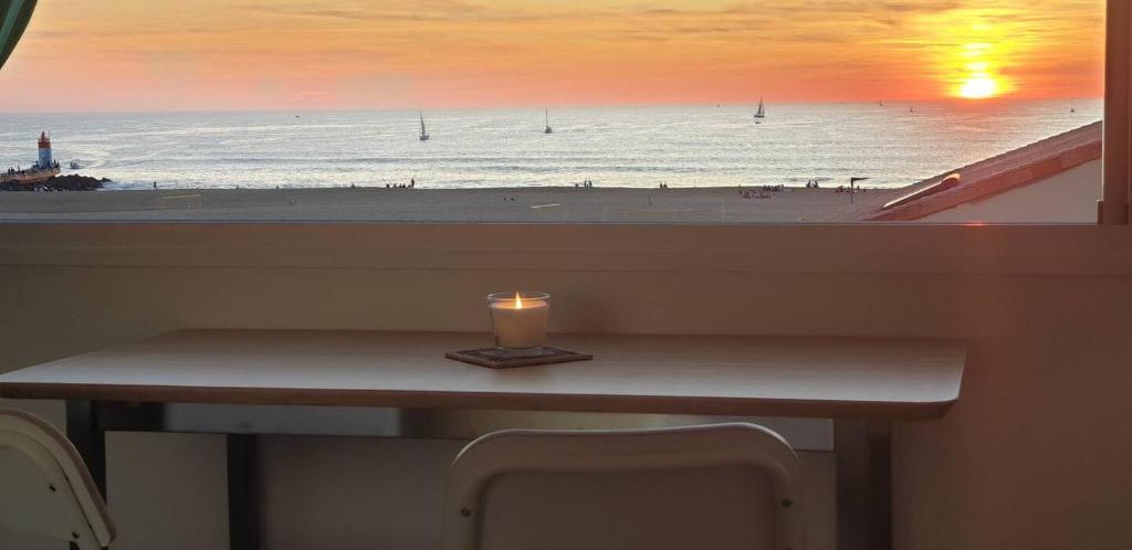 une bougie posée sur une table devant une plage dans l'établissement Capbreton - Vue Océan - Famille - Surf - Plage, à Capbreton