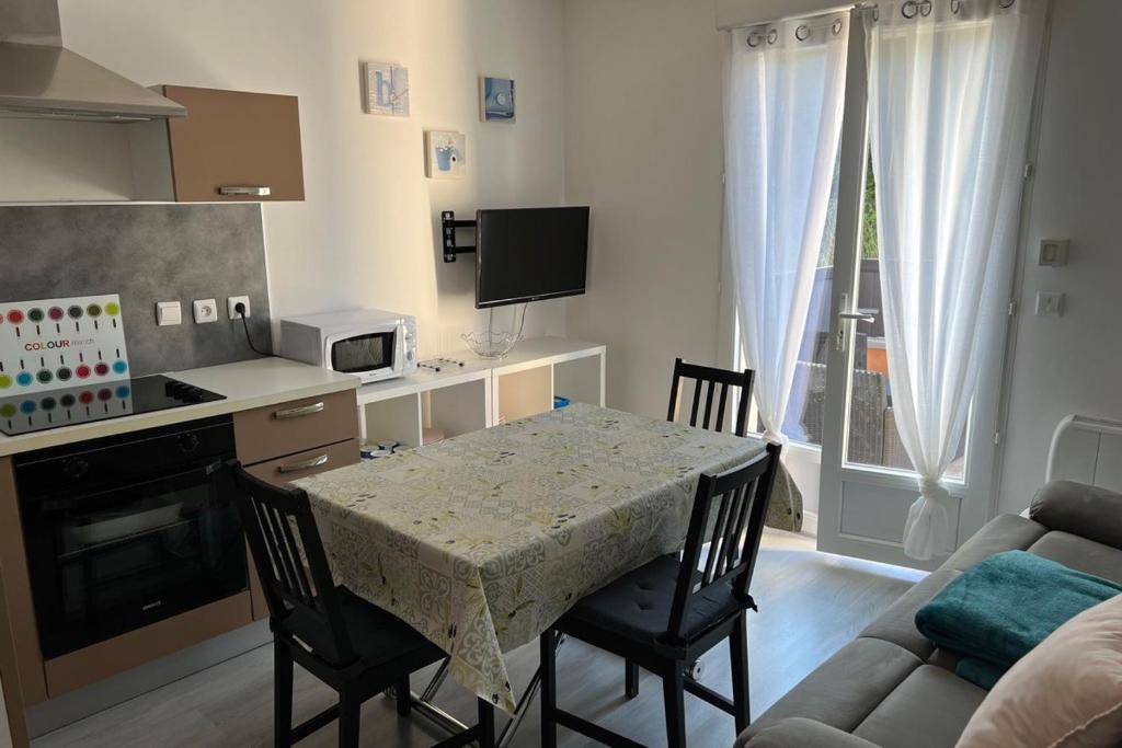 a kitchen with a table and chairs and a kitchen with a couch at Résidence Dalma appartement 1 in Cazaubon