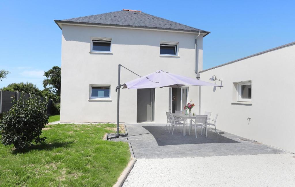une maison blanche avec une table et un parasol dans l'établissement Lovely Home In Saint-Méloir-Des-Ondes, à Saint-Méloir-des-Ondes