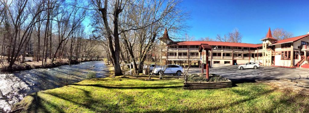 two cars parked in front of a large building at Riverbend Motel & Cabins in Helen