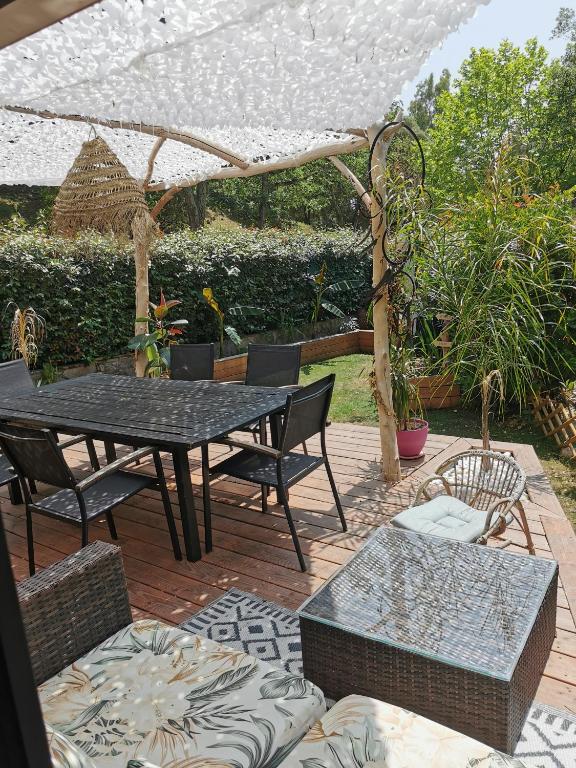 un patio avec une table, des chaises et un parasol dans l'établissement Évasion tout confort pour 4 - Domaine avec 5 piscines & activités !, à Fréjus