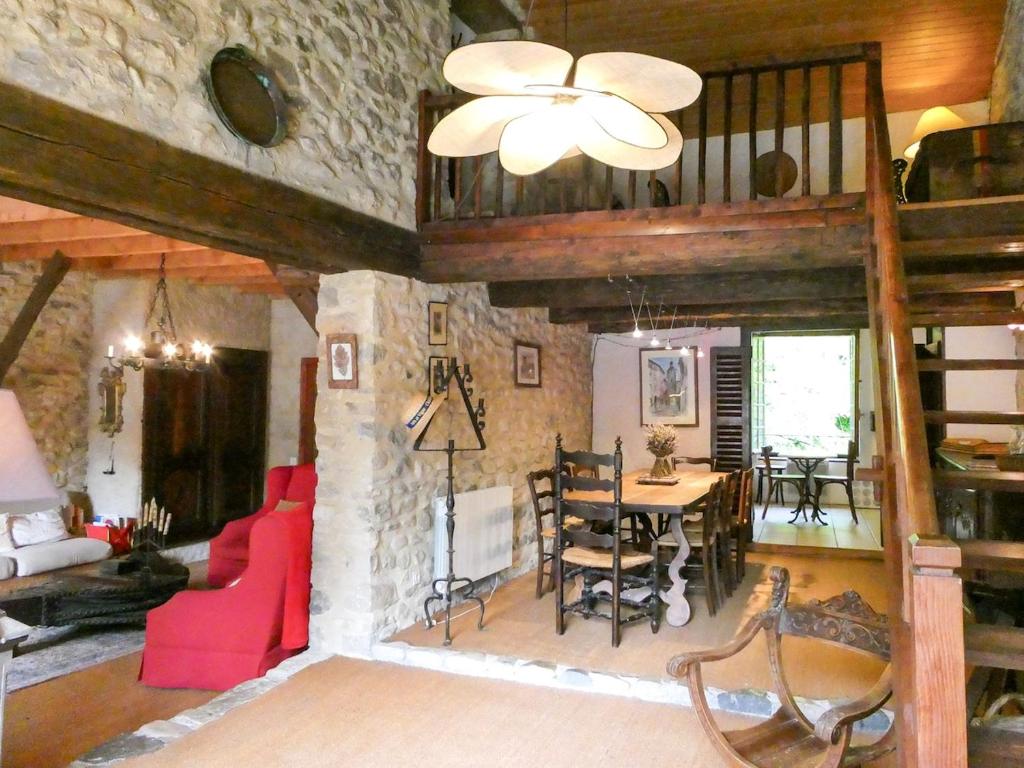 un salon avec un canapé rouge et une table dans l'établissement Maison de charme sous le soleil de la Drôme, à Châtillon-en-Diois