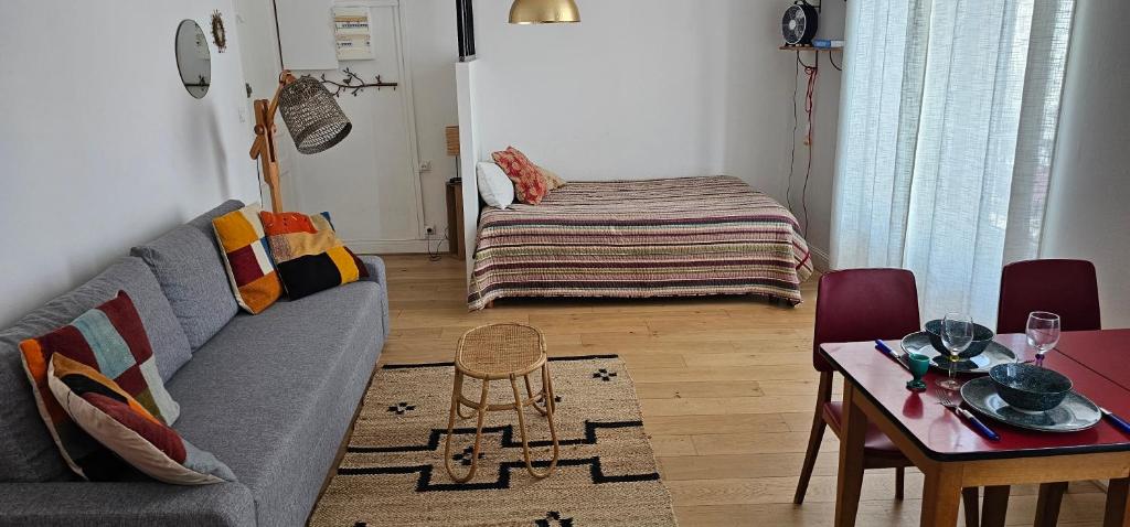 un salon avec un canapé et une table dans l'établissement Evasion ensoleillée à St Jean de Luz Studio coquet avec balcon, à Saint-Jean-de-Luz
