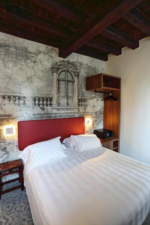 a bedroom with a large bed with a red headboard at Ai Due Fanali Adults Only in Venice