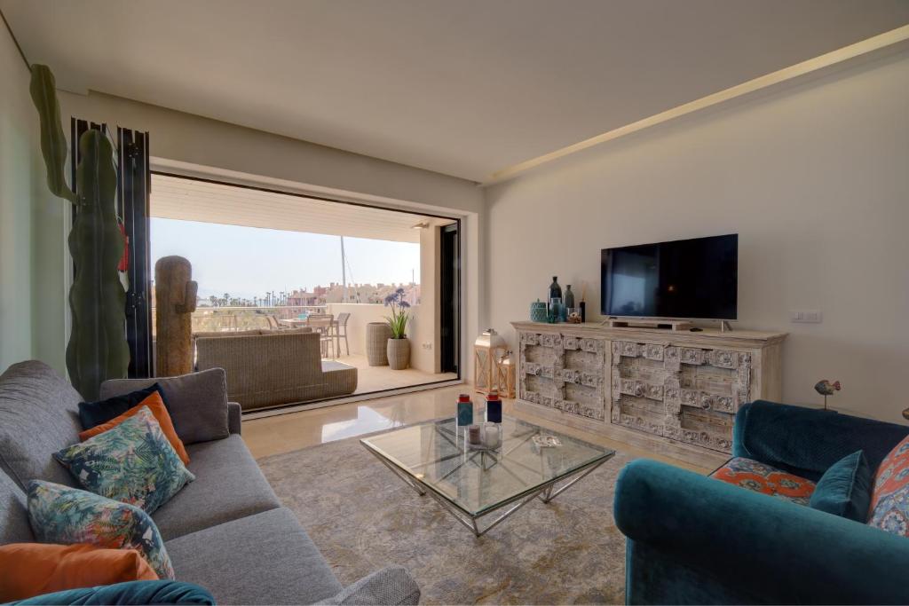 a living room with a couch and a tv at Ribera del Marlin IX Sotogrande in Sotogrande