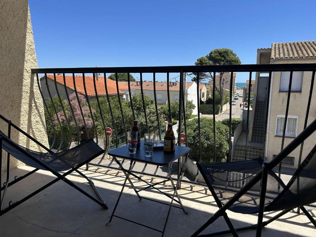 une table et deux chaises sur un balcon dans l'établissement SP920-0067 Grand appartement 3 pièces 5 couchages SAINT PIERRE LA MER, à Saint Pierre La Mer
