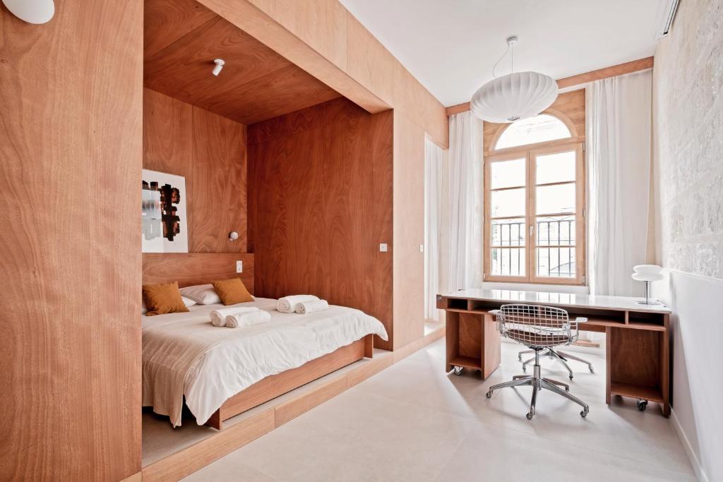 une chambre avec un lit, un bureau et une chaise dans l'établissement Bel appartement dans le coeur de Bordeaux, à Bordeaux
