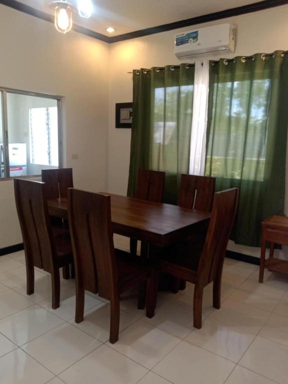 a dining room with a wooden table and chairs at Binalbagan Staycation in Sampong