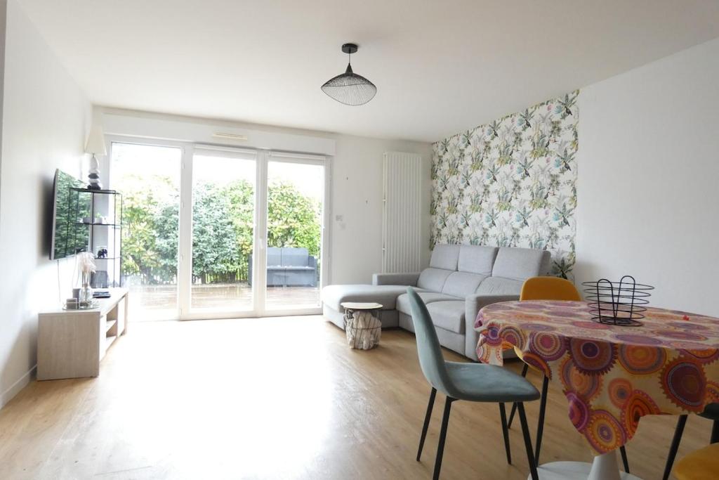 un salon avec un canapé et une table dans l'établissement Appart terrasse privée parking proche mer, à Pornichet