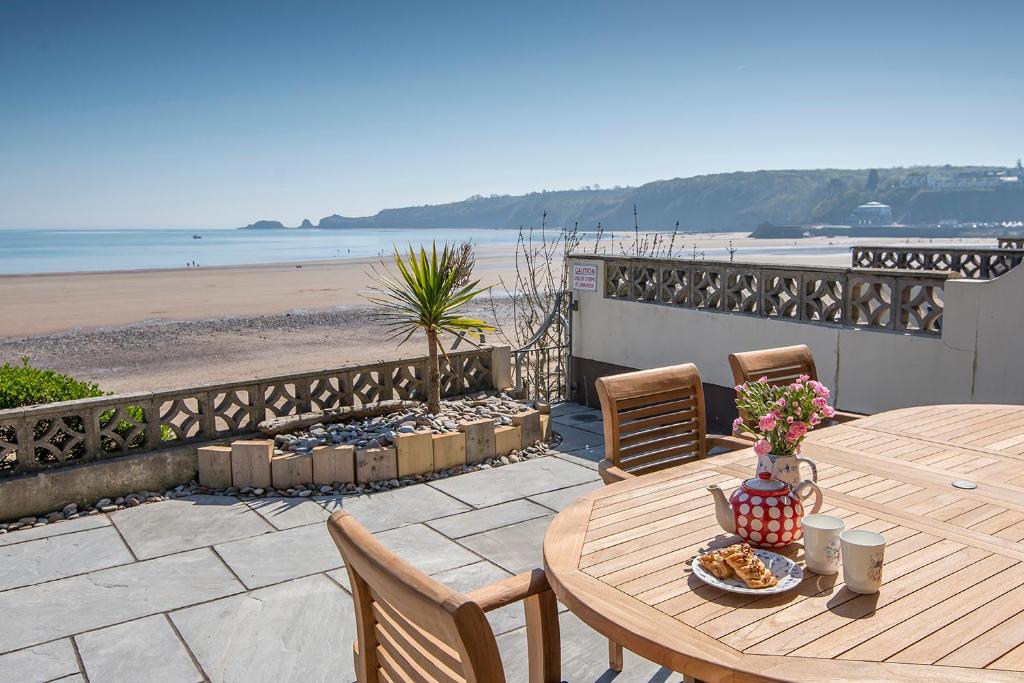 ein Tisch mit einem Teller Essen und ein Strand in der Unterkunft 5 Mariners Reach in Saundersfoot