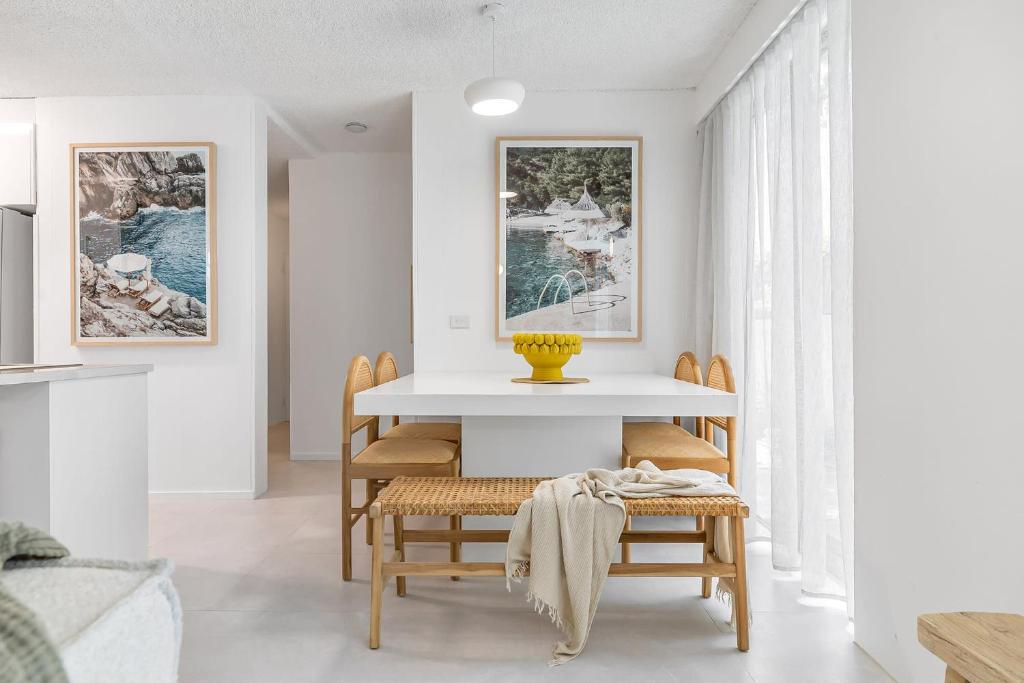 a dining room with a table and chairs at Amalfi on Alex: Seaside 2 Bedroom Retreat in Alexandra Headland