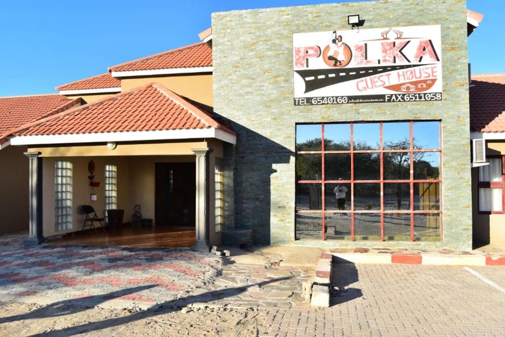 a pizza shop with a sign on the side of it at Polka GuestHouse in Tshabong