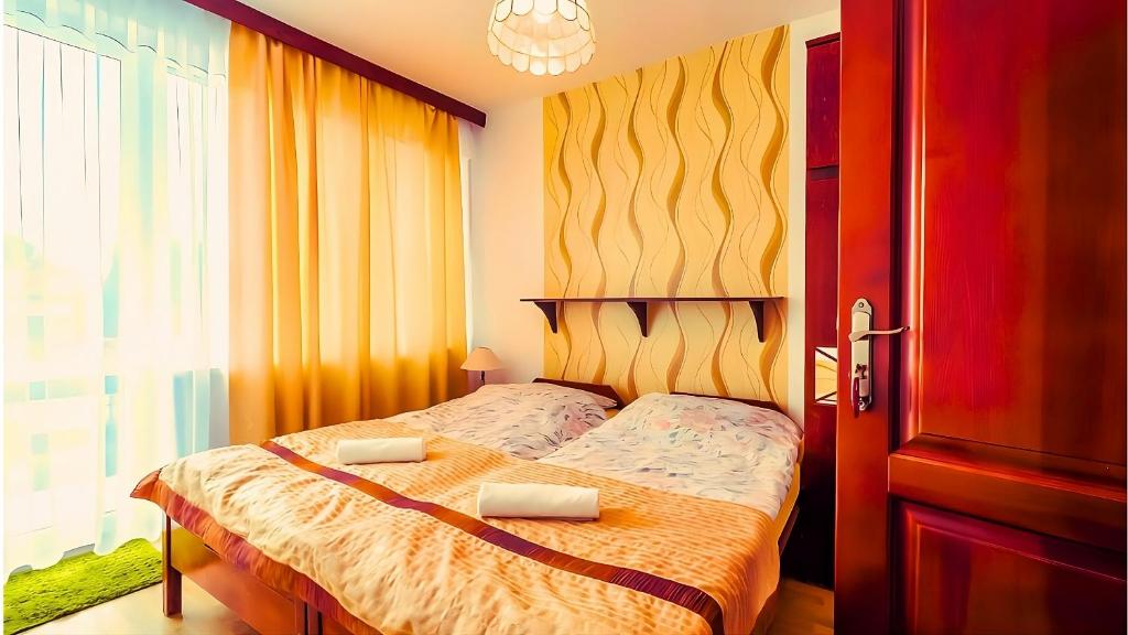 a bedroom with a bed and a large window at Lawendowy Zakątek - przytulne pokoje i pyszne śniadania in Łeba