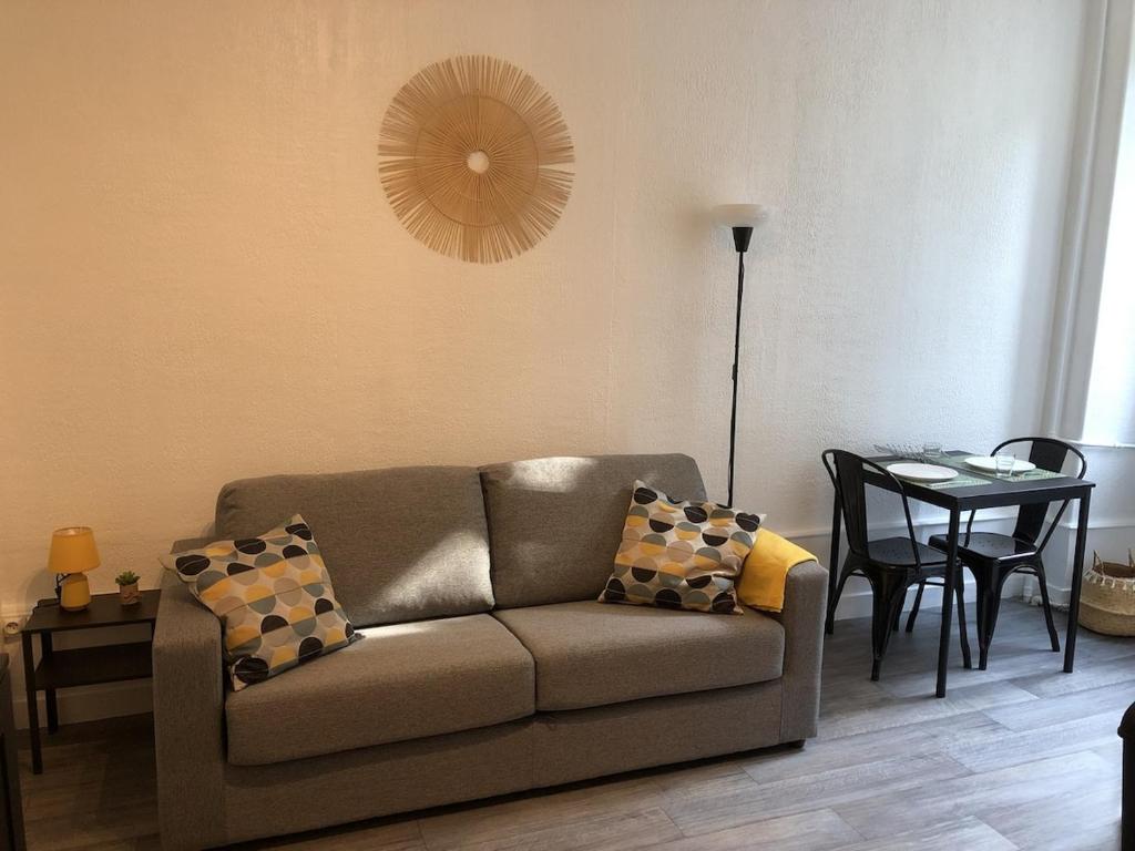 un salon avec un canapé et une table dans l'établissement Studio 18m2 Le Beau Site en centre-ville, à Aix-les-Bains