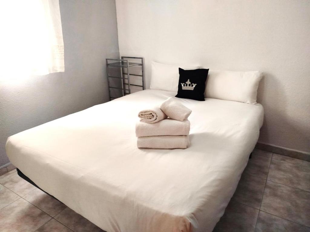 Una cama blanca con un montón de toallas. en La habitación de Santa Eulalia, en Hospitalet de Llobregat