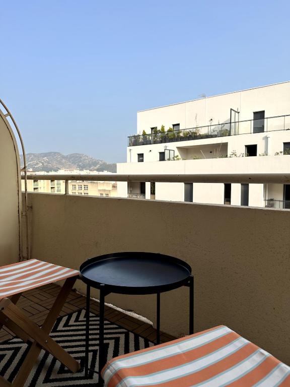 d'une table et d'une chaise sur un balcon avec vue. dans l'établissement Studio Prado near Velodrome, à Marseille