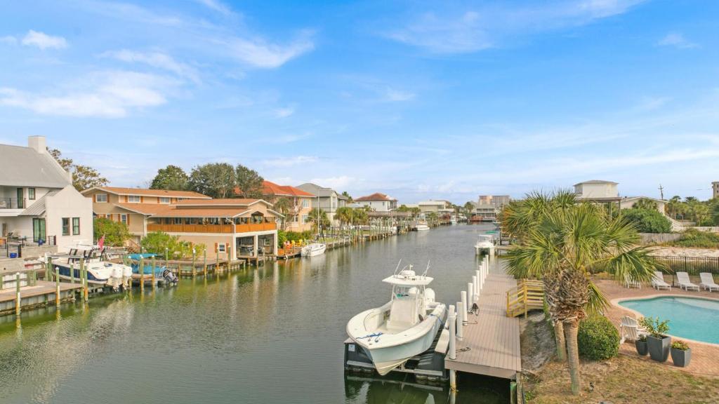 una barca è ormeggiata su un fiume con case di Holiday House a Destin