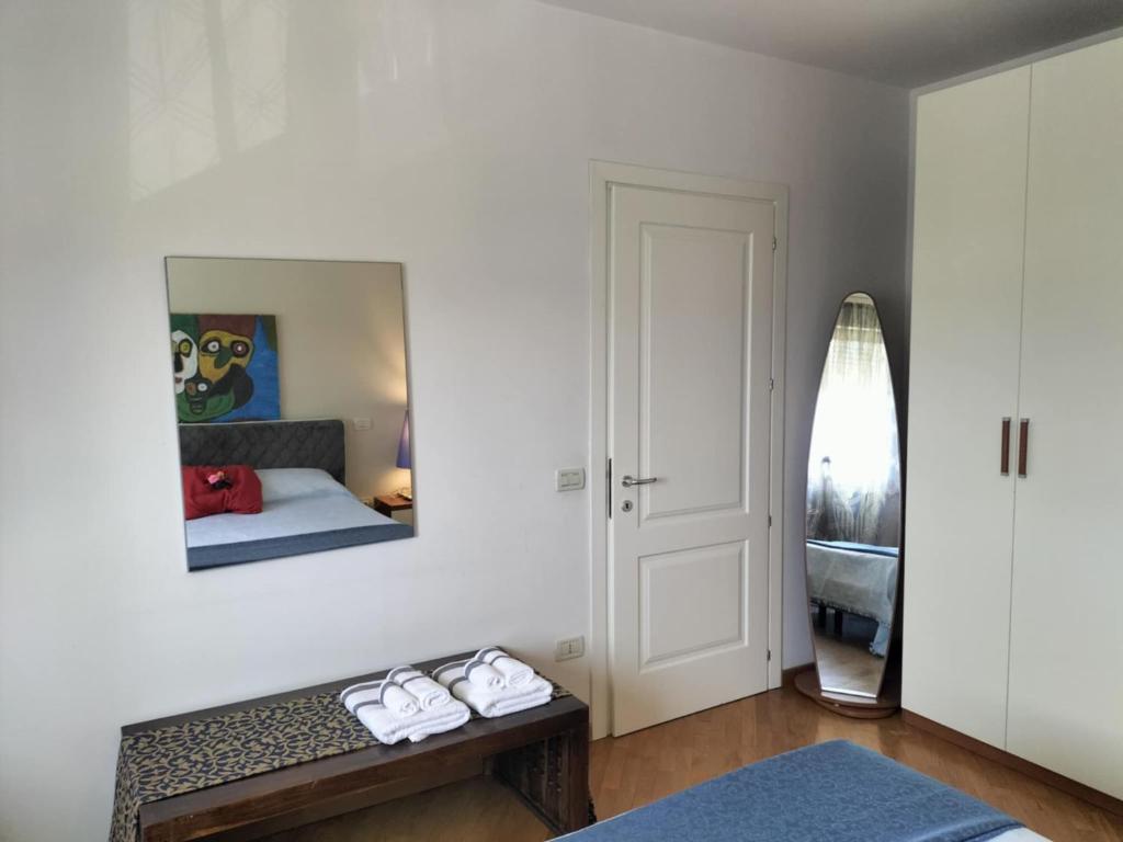 una camera con letto, specchio e tavolo di IL GIARDINO FIORITO Luxury Guest House B & B a Cesena