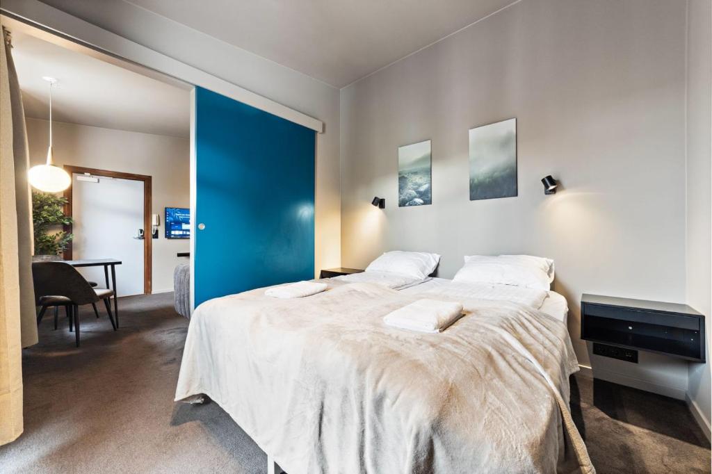 a bedroom with a large bed and a blue wall at Astro Apartments in Reykjavík