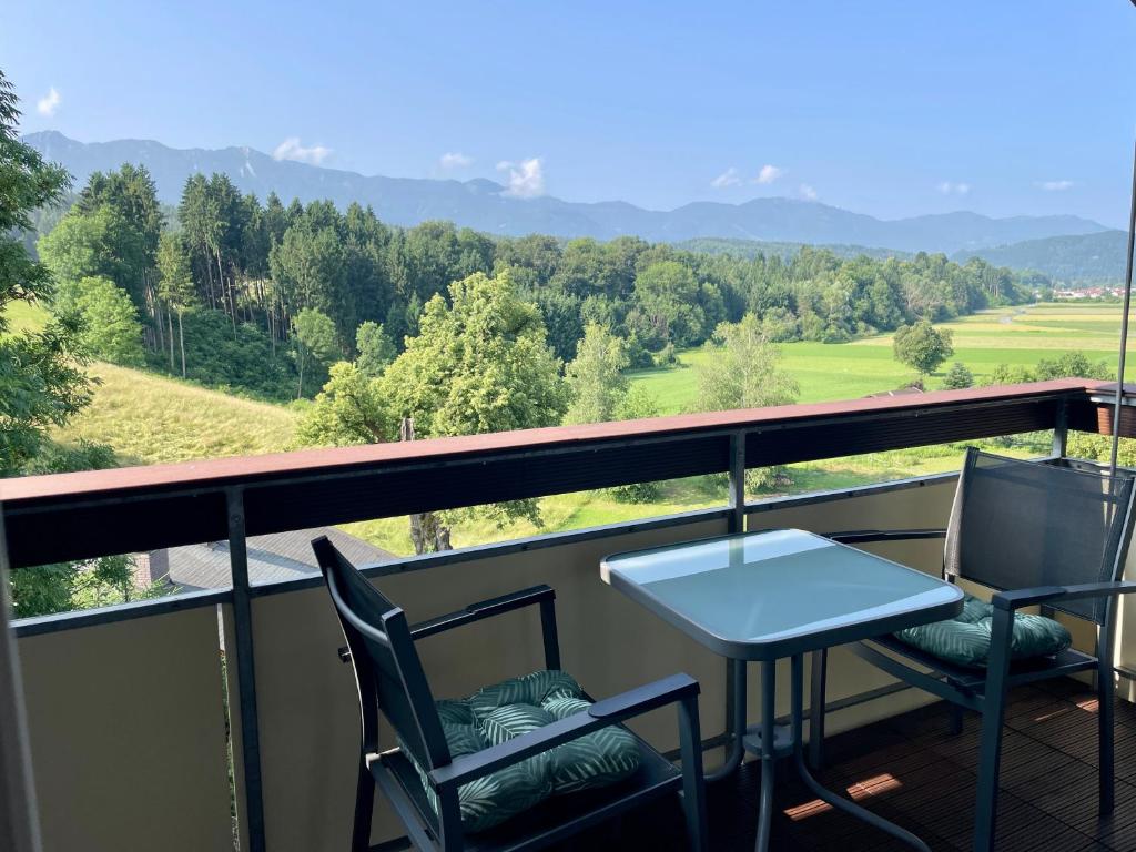 a table and two chairs on a balcony with a view at Moderne Oase mit Panorama-Blick in Villach