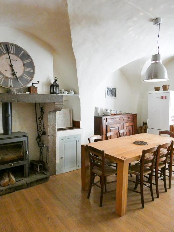 une cuisine et une salle à manger avec une table et une horloge dans l'établissement Maison typique en plein cœur du village, à Châtillon-en-Diois