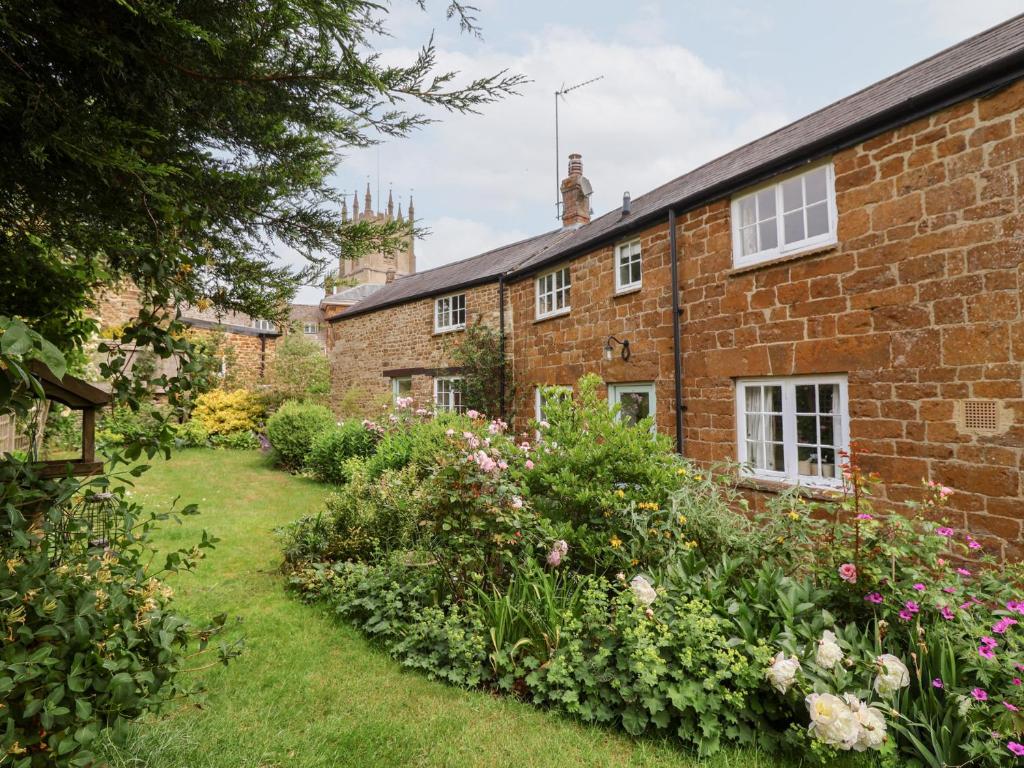 a garden in front of a brick house at Magdalen Cottage in Banbury