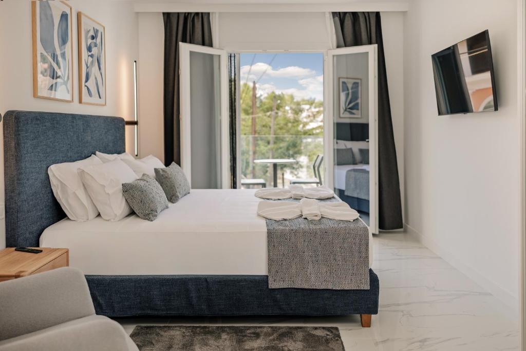 a bedroom with a large bed and a large window at Kassiopi Piazza Suites in Kassiopi