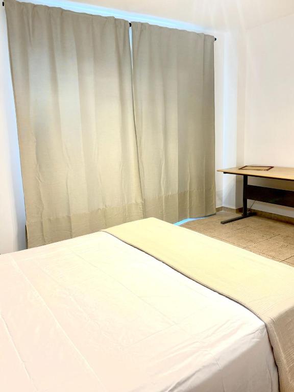 a bedroom with a bed and a table and a window at casa almasol in Infernetto