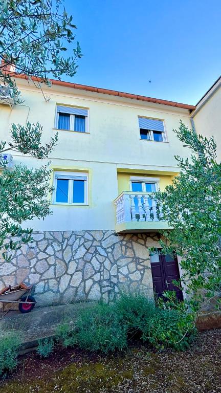 a building with a stone wall and a balcony at Comfort apartment Kali - with panoramic view in Kali