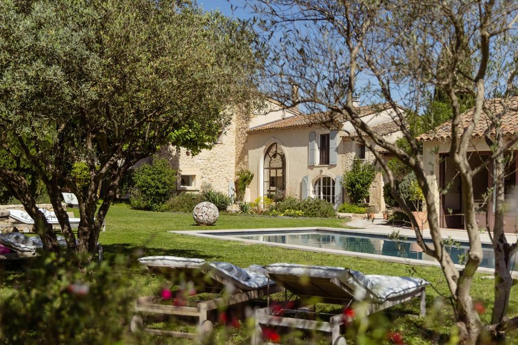 a house with a swimming pool in a yard at MAS MILLÉSIME - Chambre double - petit déjeuner - piscine - Mas du XVIIIème siècle proche Saint-Rémy-de-Provence in Mas blanc des Alpilles