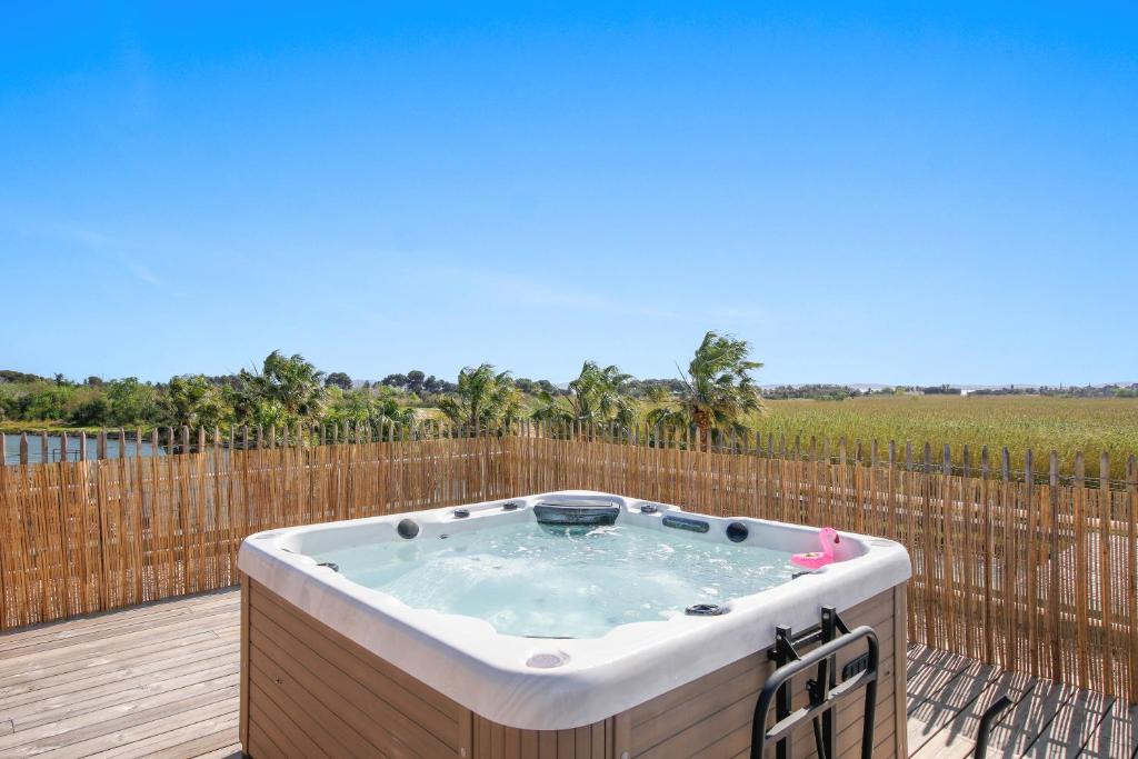 un bain à remous sur une terrasse avec une clôture dans l'établissement Palmira Duplex jacuzzi, à Hyères