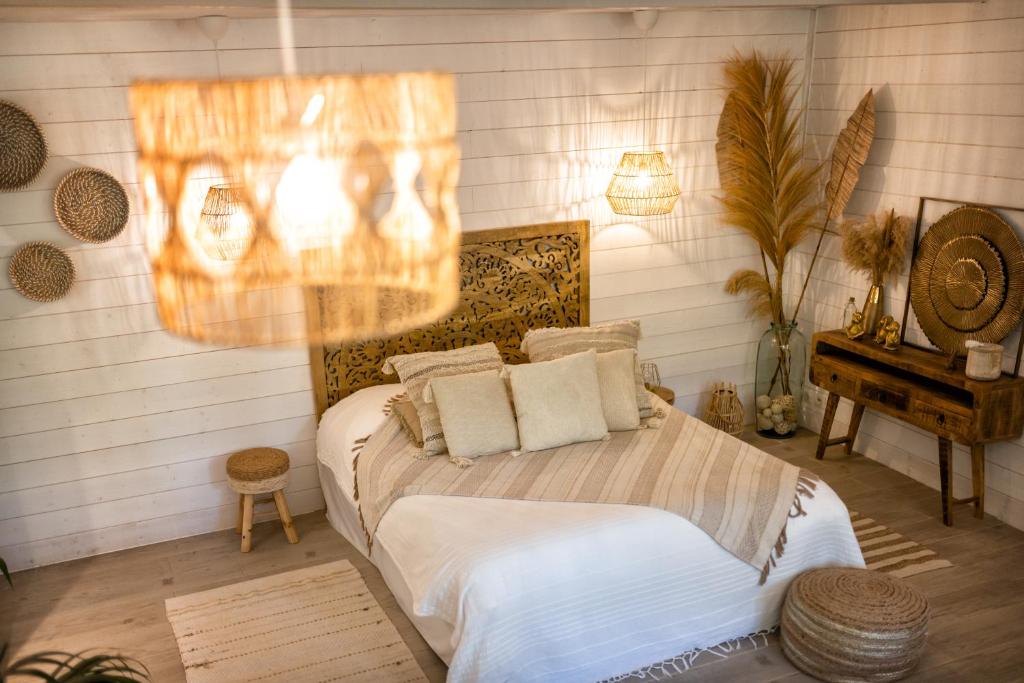 a bedroom with a bed in a room with a piano at Nuitées Bohèmes Hôtel & Spa in Gajan