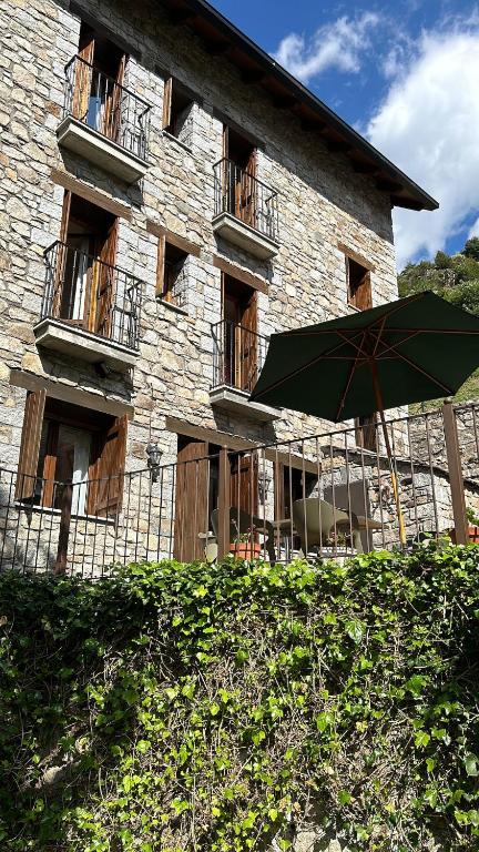 a green umbrella sitting in front of a building at Casa Rural Barranco in Bielsa