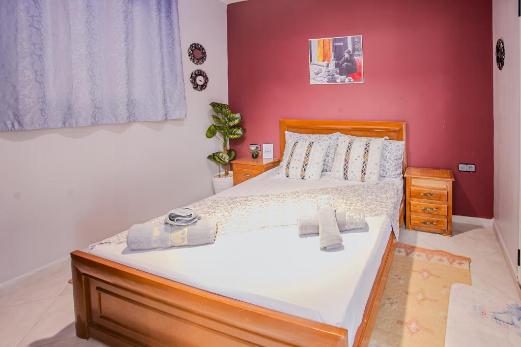 a bedroom with a large bed with a red wall at The Rina Hostel in Agadir