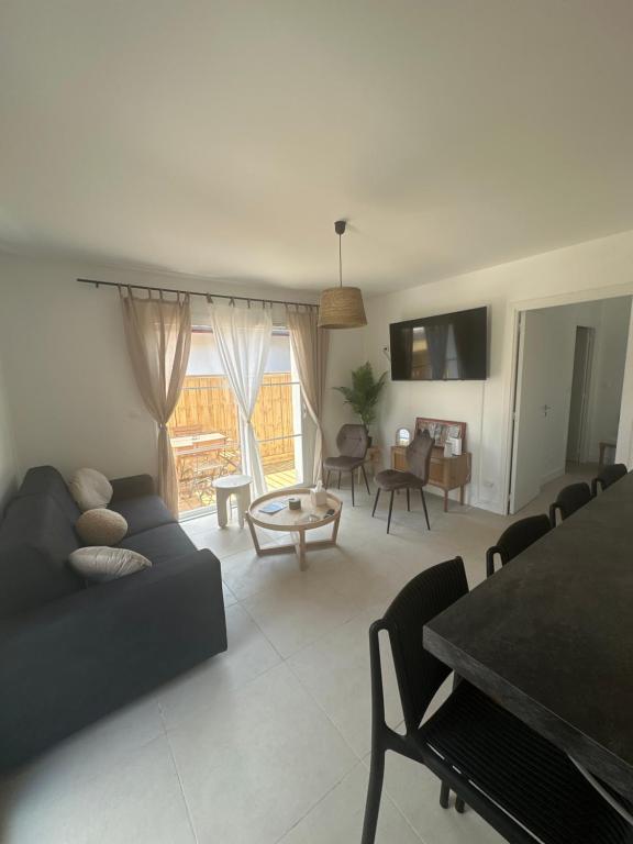 un salon avec un canapé et une table dans l'établissement Maison cosy à 10 minutes de la plage, à Gujan-Mestras
