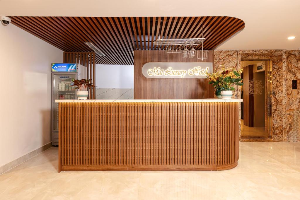 a lobby with a wooden counter in a building at MAI Luxury Hotel Ninh Binh in Ninh Binh