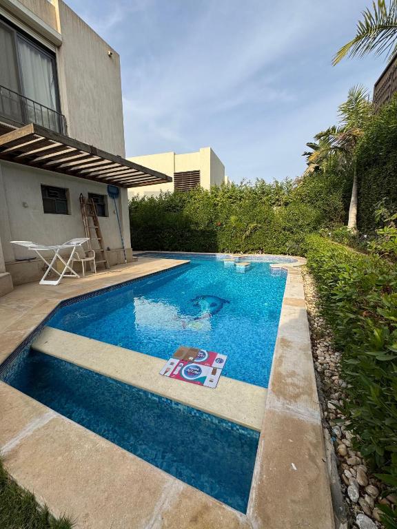 a swimming pool in front of a house at villa c182 in Sheikh Zayed