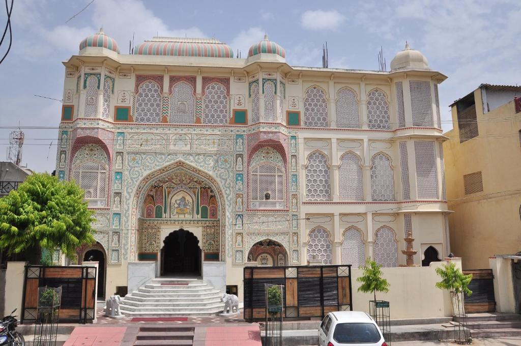 um grande edifício com uma fonte em frente em Rani Mahal Hotel em Jaipur