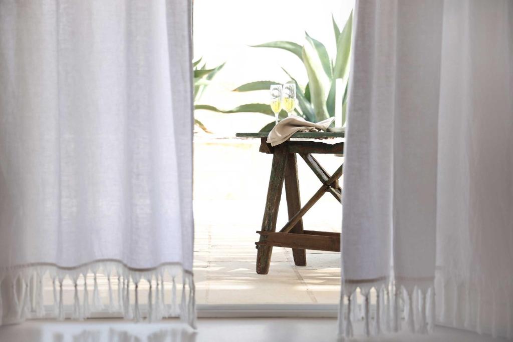 a room with a table with a white curtain at Masseria Borgo Sentinella in Torre dell'Orso