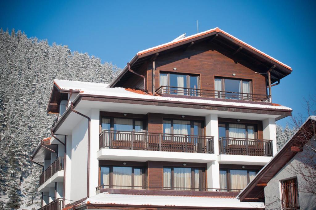 a tall building with a balcony on top of it at Family hotel Iskar in Govedartsi