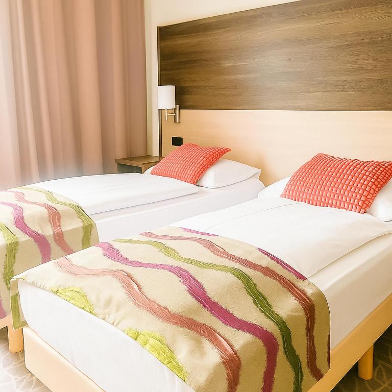 A bed or beds in a room at Arion Cityhotel Vienna